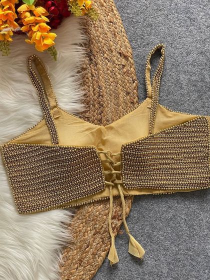 The back of the golden pearl blouse, featuring the same adjustable lace-up design.