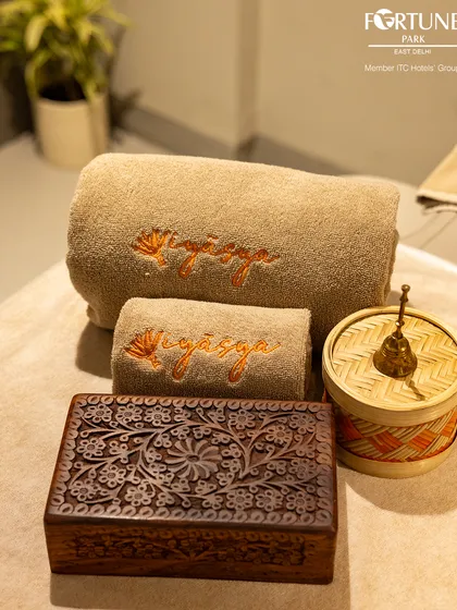 A closer look at the details that create a serene atmosphere. From the intricately carved wooden box to the soft, branded towels, every element is chosen to enhance your sense of peace.