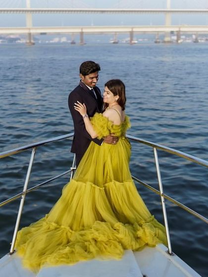 A full view of the couple on the yacht, showing the stunning lime green gown and the beautiful sea backdrop.