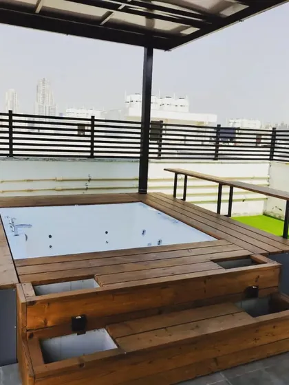 A terrace room with an extended veranda and an open jacuzzi, all clad in beautiful thermopine wood.