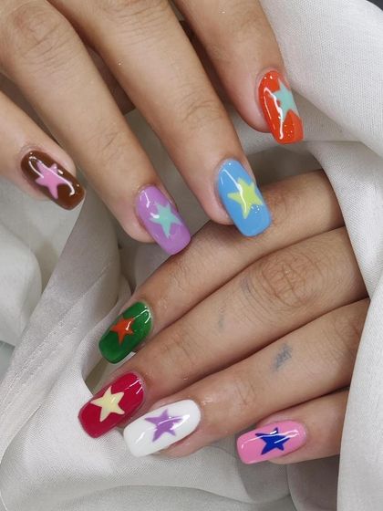 A fun and colorful design with a different colored star on each nail, creating a playful and vibrant look.
