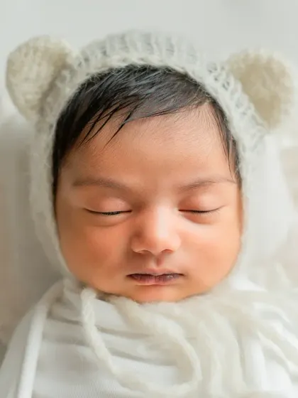 An intimate, tight close-up of the baby's face, emphasizing their perfect, sleepy innocence.
