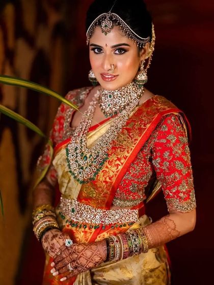 A full bridal look, where the deep henna stain on the hands and arms beautifully complements the bride's magnificent jewelry and saree. The color is rich and even from fingertips to elbow.
