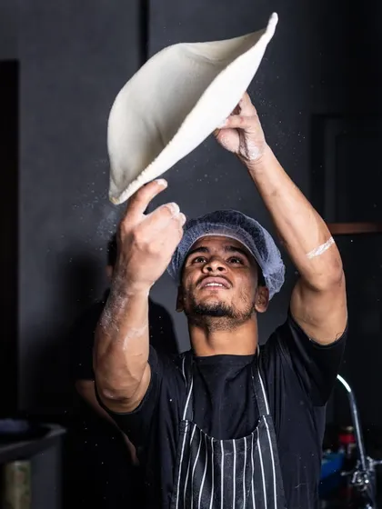 My pizza maestro at work. The dough undergoes a comprehensive process, and you can see the skill in the way it's tossed.