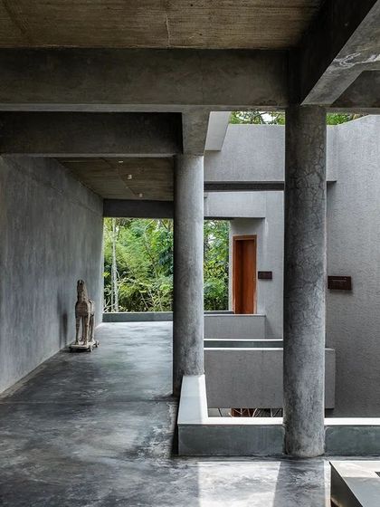 The play of light and shadow along a corridor at Anahaspa, where a wooden horse sculpture adds a touch of artistry to the minimalist space.