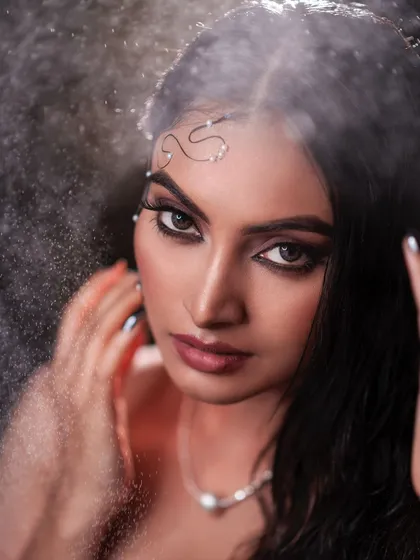 This close-up captures the dramatic effect of the in-studio rain machine. The water spray adds texture and movement, transforming a simple portrait into a dynamic piece of art.