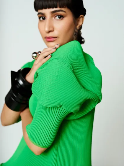 A portrait showing the clean makeup and bold, puffed sleeve detail of the green dress.