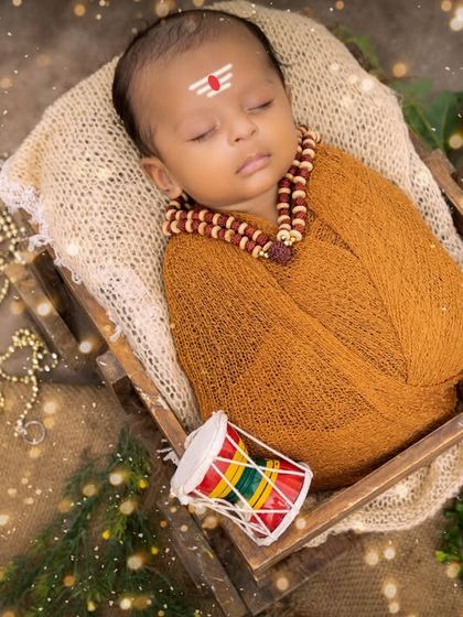 A newborn styled as a tiny Lord Shiva, complete with a tripundra on the forehead and rudraksha beads. This divine-themed newborn shoot is a unique way to celebrate your baby's arrival.