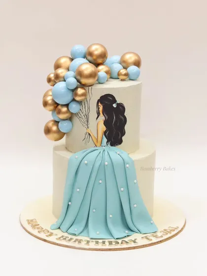 An elegant cake for a 25th birthday, featuring a hand-painted girl in a flowing blue fondant dress holding a bouquet of balloons.