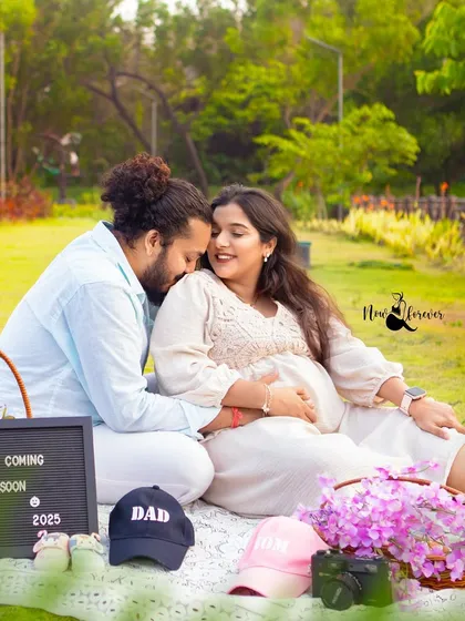 A perfect picnic setup for a pregnancy announcement. The letterboard, sonogram, and little "Mom" and "Dad" hats make this such a sweet and personal outdoor scene.