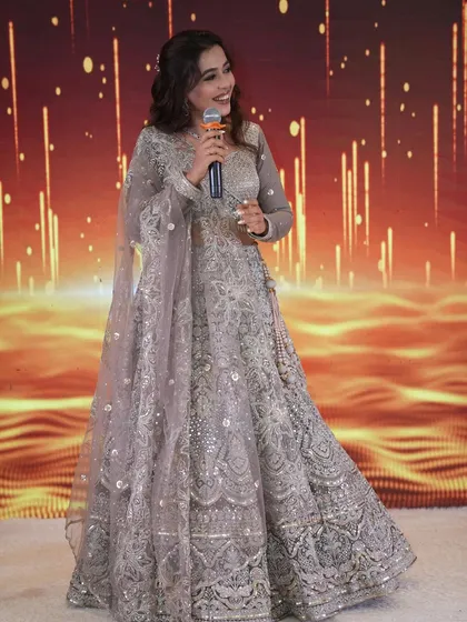 The bride takes the stage during her engagement ceremony, looking confident and radiant.