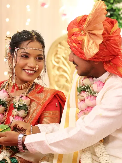 A sweet moment of exchange between the bride and groom during a ritual. Her makeup is glowing, and her smile is genuine.