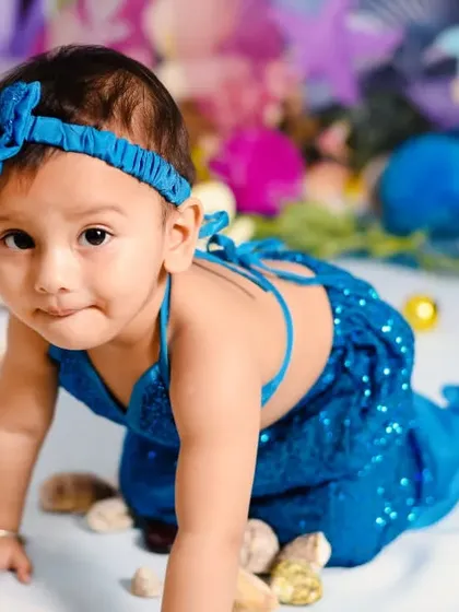 A close-up of our little mermaid, showing off her beautiful blue bow and curious eyes. I focus on capturing these sweet details during our themed sessions.