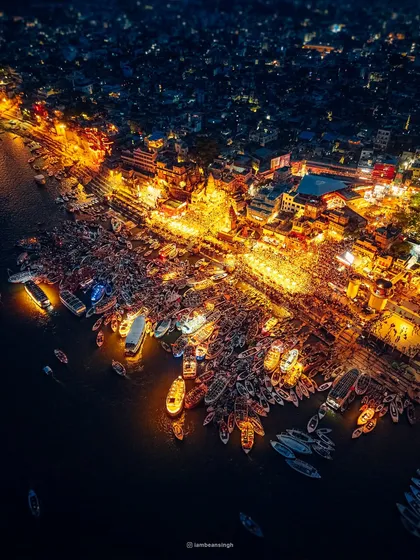 The Ganga Aarti at Dashashwamedh Ghat in Varanasi, seen from the sky. At night, the ghat transforms into a sea of light and devotion. This drone shot captures the thousands of devotees and boats gathered to witness the ceremony, a truly spiritual spectacle that connects you to something ancient and divine.