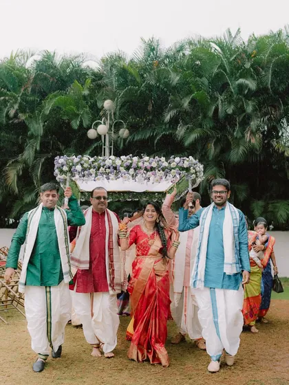 The bride's grand entrance. A beautiful moment from A & N's Muhurtham as the bride is escorted by her family under a floral canopy.