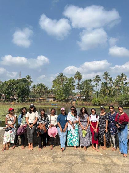 Our group posing in front of a serene lake surrounded by coconut trees on our coastal trip.
