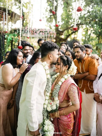 The groom's gentle kiss on his bride's forehead, surrounded by smiling family and friends. These are the candid, emotional moments we live to capture.