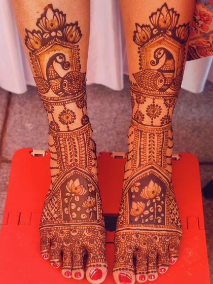 A traditional bridal leg mehendi with beautiful peacock and lotus motifs, perfect for a classic wedding look.