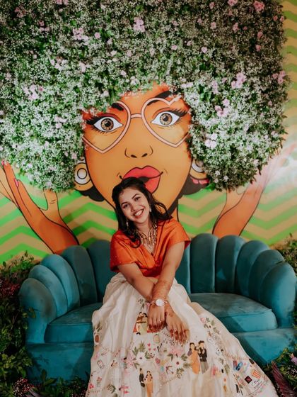 A fun and quirky shot of the bride posing in front of a colorful, artistic mural at her carnival party.