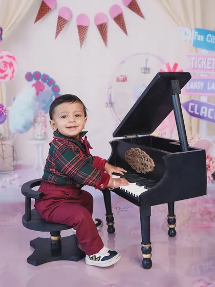 A mini maestro at his piano. The carnival theme includes fun props like this to encourage playful and interactive photos.