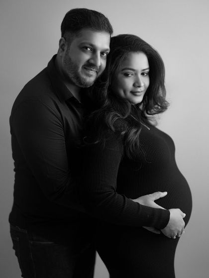 A classic black and white portrait that exudes elegance and connection. His hand gently rests on her bump, a simple and loving gesture.