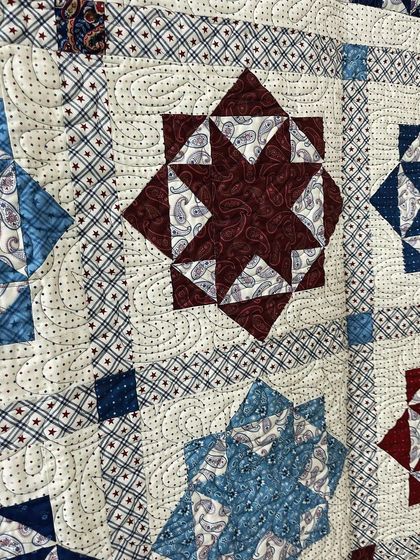 A close-up of a single Lone Star block, where you can see the paisley fabric and the stippling quilting.