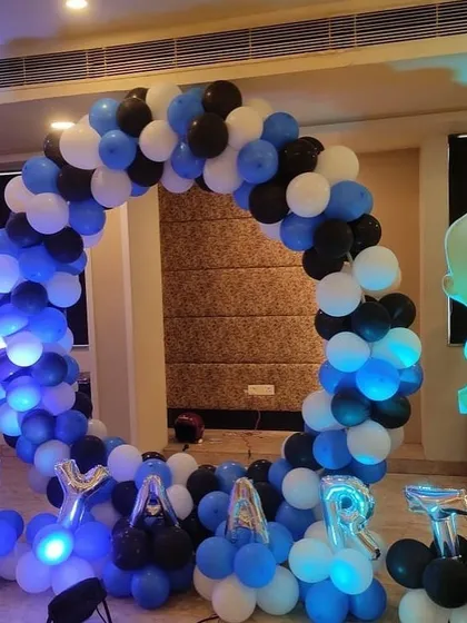 A Boss Baby themed circular balloon arch in blue, black, and white, perfect for a photo booth.