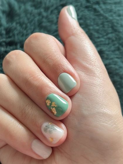 The full hand showing the balanced and artistic teal manicure.
