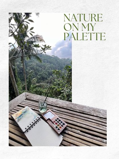 A sketchbook and watercolor palette rest on a bamboo table overlooking a vast, green valley. This image captures the moment of inspiration, where nature itself becomes the palette for a new design.