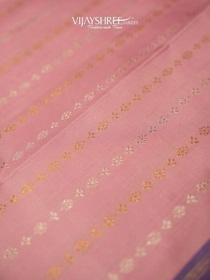 The body of the pink saree features delicate floral buttas in alternating gold and silver zari.