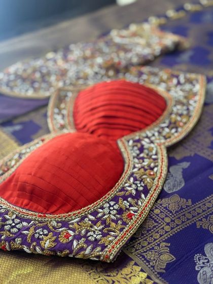 The back of the purple and red blouse, with a pleated red panel.