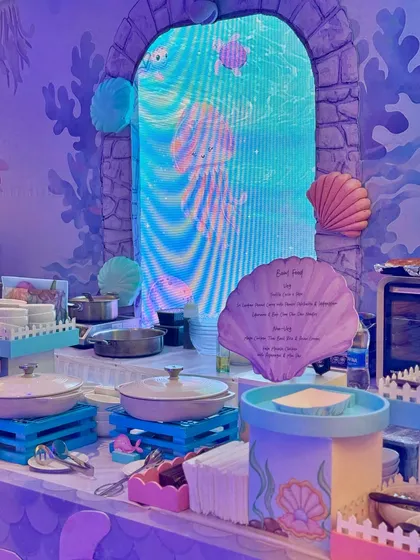 From a pastel soft play area and a cotton candy cart to a buffet with an LED screen backdrop showing aquatic life, every element was designed to immerse guests in Miraya's mermaid world.