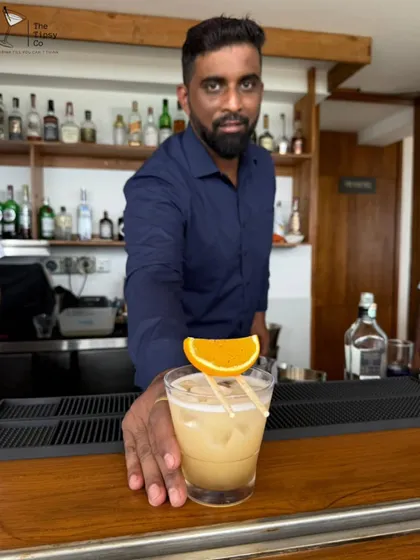 One of our expert mixologists presenting a freshly made cocktail. We serve every drink with style and a personal touch.