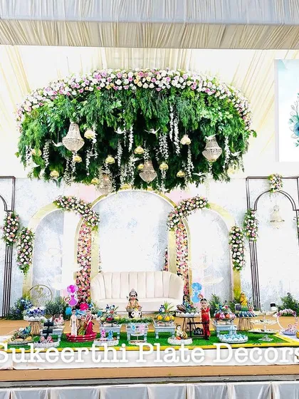 For this grand baby shower, I created a beautiful display in front of an elegant floral stage. The setup includes a variety of decorated platters on German silver stands, all coordinated to create a memorable welcome for the new baby.