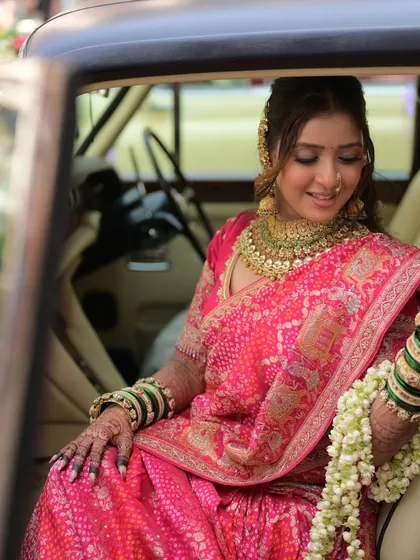 A moment of quiet elegance. The bride's soft glam makeup looks flawless as she sits in a vintage car, ready for her new beginning.