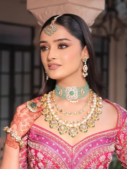 A portrait of the "Radha" inspired bride. Her makeup features soft-focus skin, rosy hues, and fine detailing around the eyes and lips for a modern, minimalist vibe.