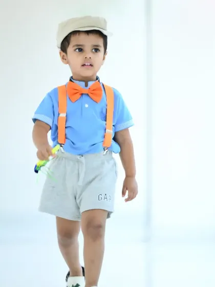 A full-body shot of the little boy in the Blippi-inspired outfit.