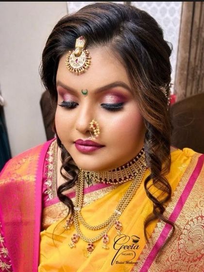 A close-up of a client's Maharashtrian bridal look. The focus is on the Thushi choker, layered necklace, and the distinctive crescent-shaped bindi.