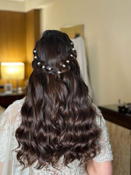 A delicate and intricate half-up style for a welcome dinner. I created two parallel braids and adorned them with tiny pearl flowers for a sophisticated look.