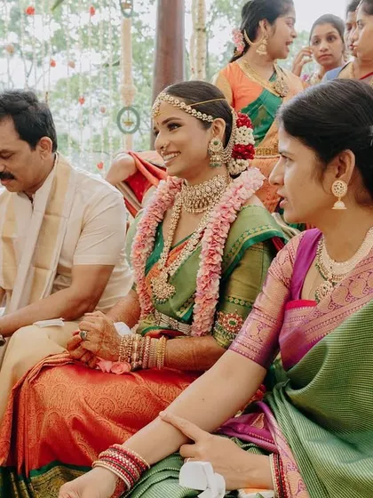 The bride with her family during the ceremony. Her makeup is fresh and bright, ensuring she looks radiant and feels comfortable throughout the long day of rituals.
