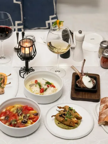 A full table setting showcasing a variety of our dishes, from small plates to main courses, ready for a feast.