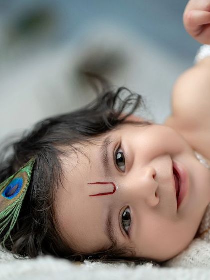 That unforgettable face. This close-up of a baby Krishna captures his beautiful smile and expressive eyes.
