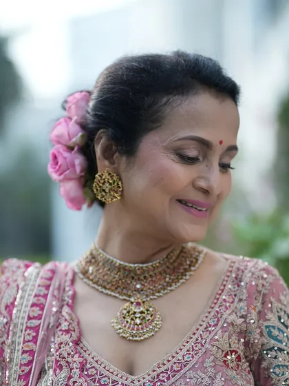 A close-up showing the delicate floral hair accessory and the soft, glowing makeup. This look is a perfect example of timeless, understated elegance.