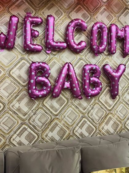 A close-up of the "Welcome Baby" foil balloons with a cute heart pattern. It's these small details that make a decoration feel extra special and personalized.