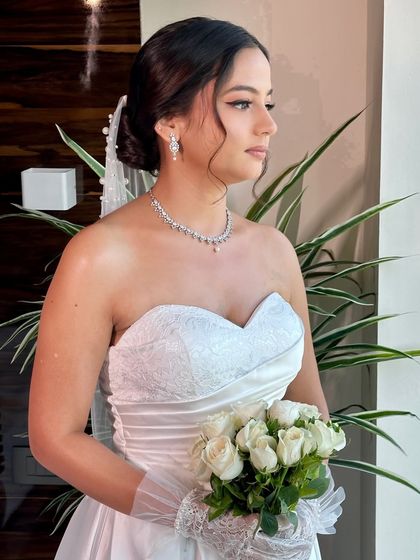 Beracah holding her bouquet of white roses. Her complete look, from the delicate veil to the soft makeup, is a perfect example of timeless Christian bridal beauty.
