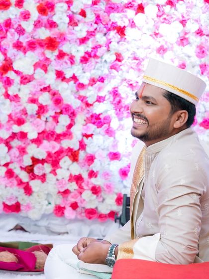 A candid portrait of the groom during a traditional ceremony, smiling happily. We make sure to capture individual moments of joy for both the bride and groom.