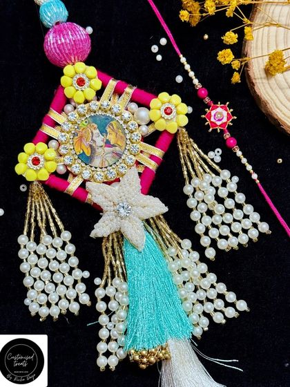 A vibrant and traditional Radha Krishna Lumba set. The centerpiece features a divine image, surrounded by colorful threads, pearls, and tassels, making it a truly special piece.