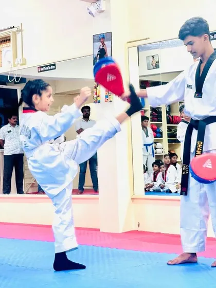 A young student practices her kicks on a target, building confidence and skill.