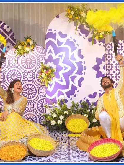 The couple having a blast with color smoke guns, adding another layer of fun to their Haldi.