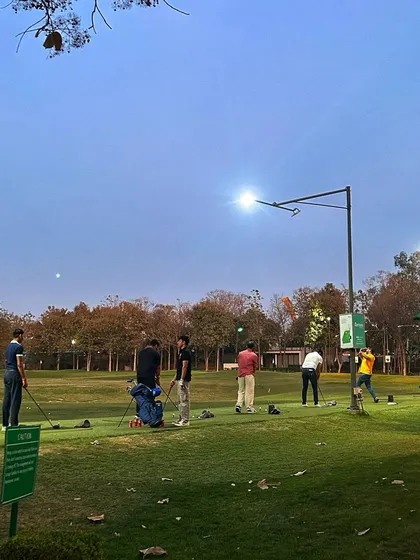 As evening descends, the floodlights turn on, allowing for practice to continue into the night.